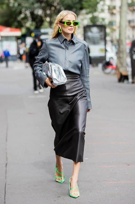 Leonie Hanne vestita di grigio porta una borsa metalizzata durante la Fashion Week