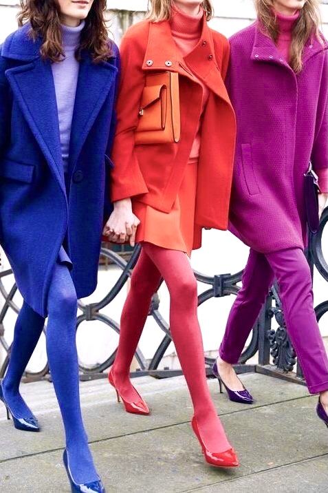 tre ragazze che passeggiano mano nella mano me indossano vestiti molto colorati
