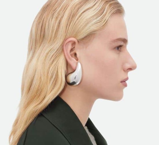 modella bionda che posa di profilo per mostrare bene orecchini argento